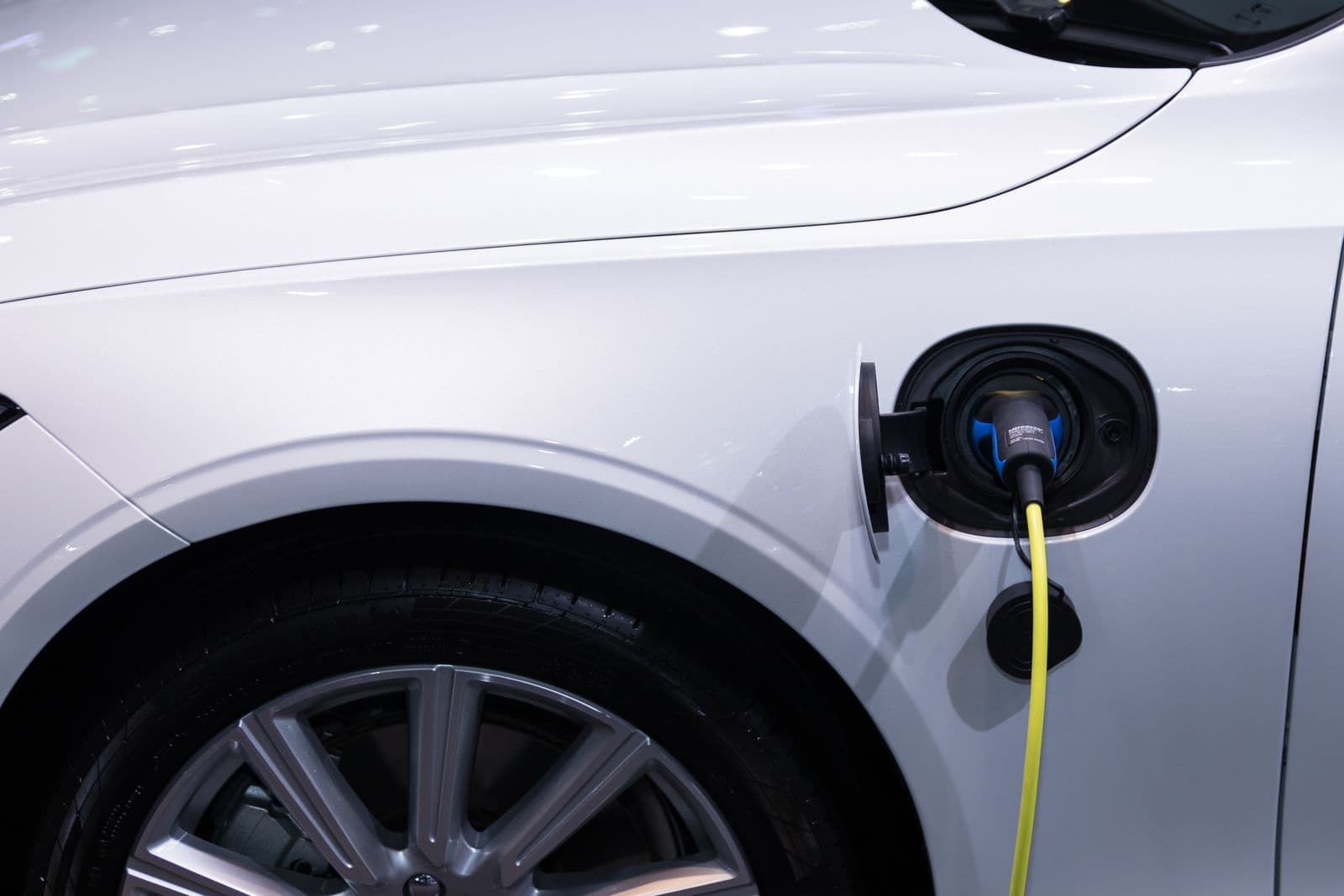 Close-up of an electric vehicle charging port with a charging cable connected